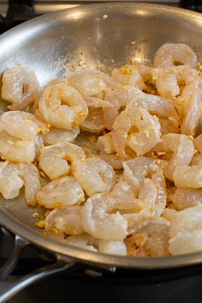 shrimps being cooked in a pan.