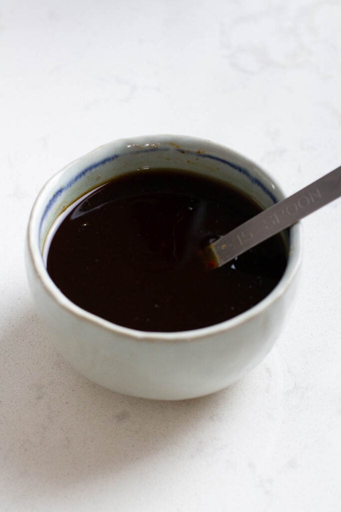 Bulgogi sauce in a small bowl with a silver spoon.