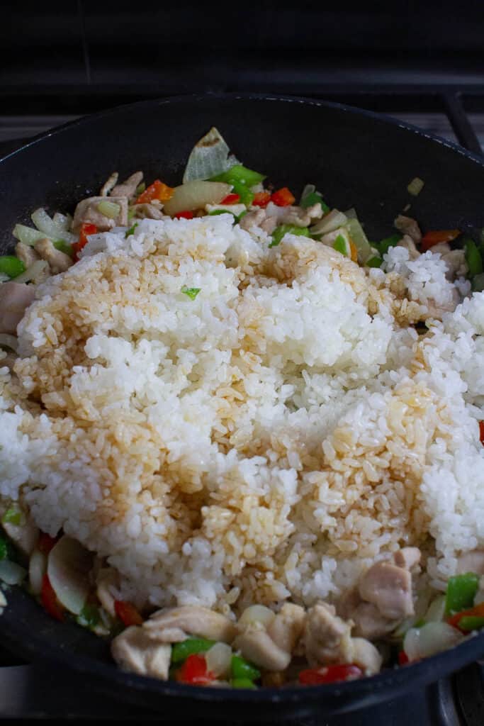 Rice, vegetables and chicken being cooked for making fried rice.
