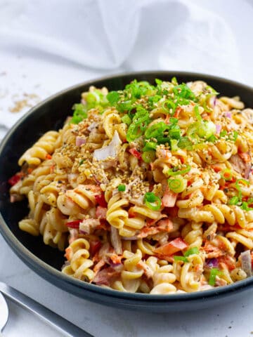 Close up shot of spicy tuna pasta with scallion sesame topping.