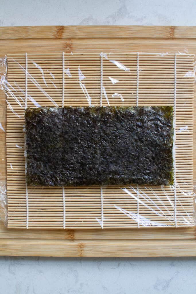 Top view of nori and rice underneath for making uramaki (inside out sushi rolls).