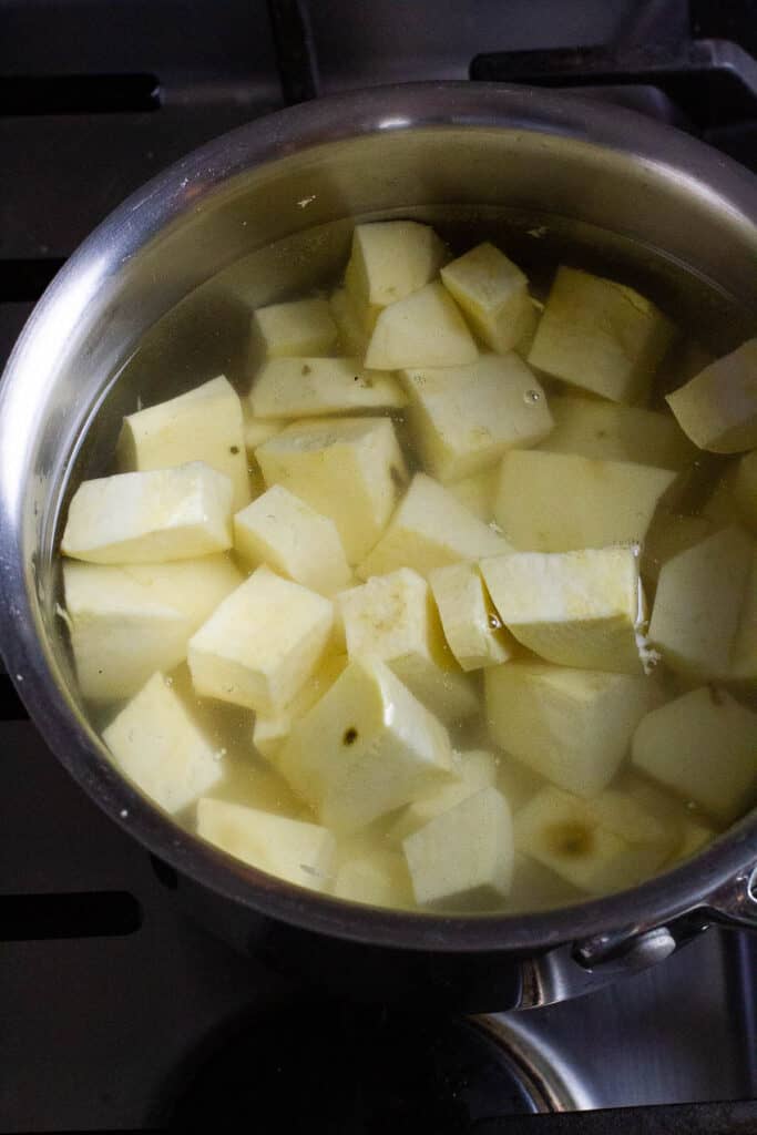 Japanese sweet potato cubes being boiled in a saucepan.