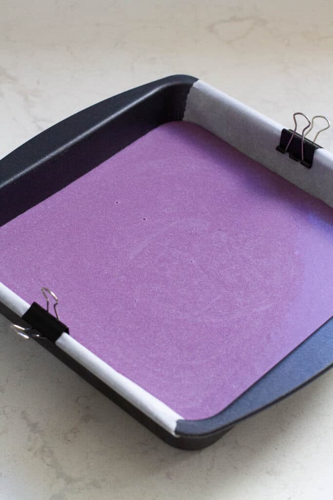Ube mochi batter in a square pan.