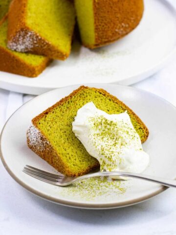 A slice of matcha chiffon cake with whipped cream topping.