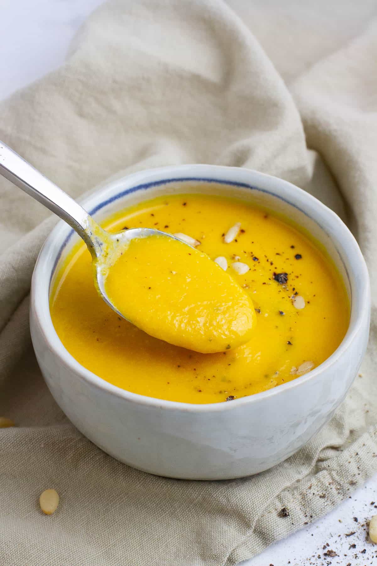 Carrot cumin soup being spooned.