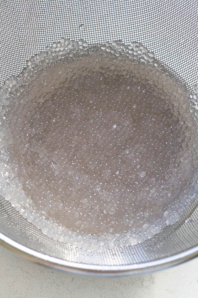 Cooked sago in a strainer.