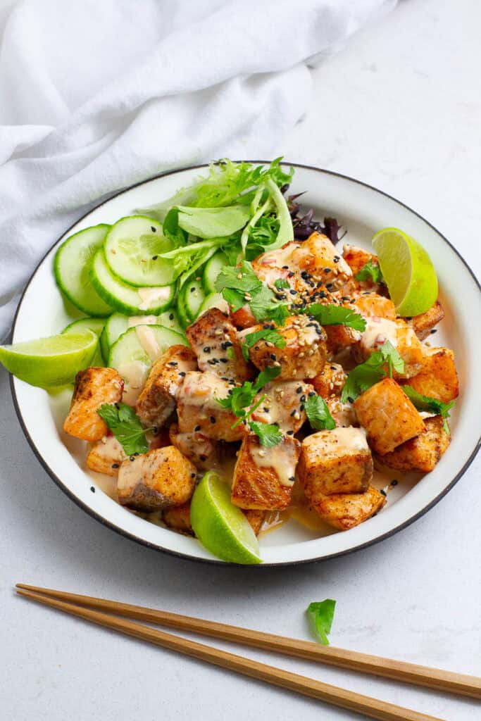 Bang Bang Salmon bites on a round plate.