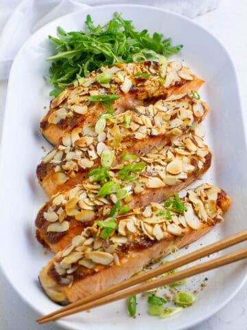 Four almond crusted salmon on a oval plate.
