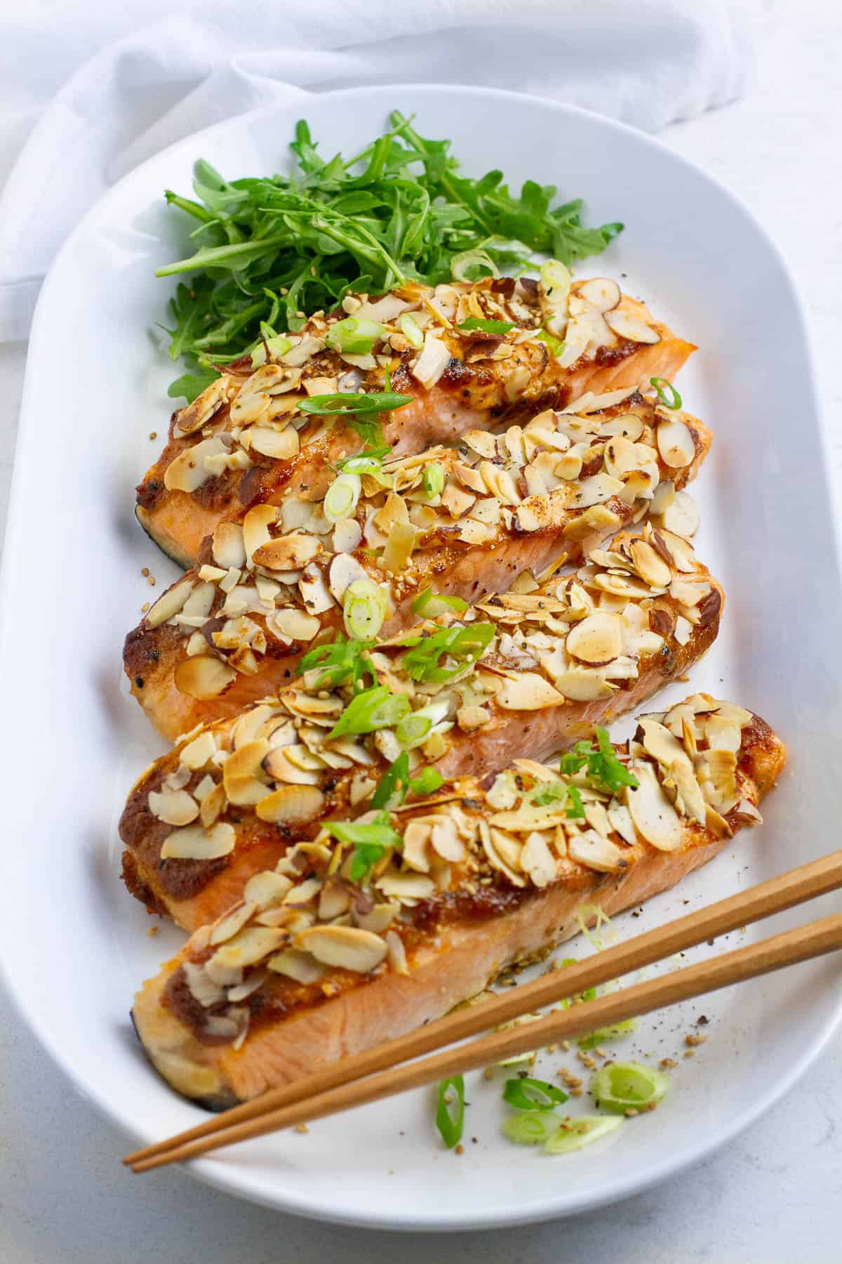 Four almond crusted salmon on a oval plate.