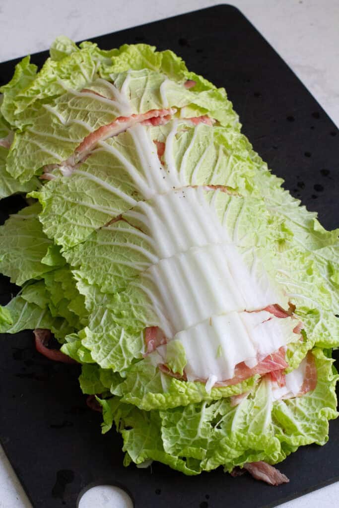 Layered napa cabbage and pork cut into pieces.