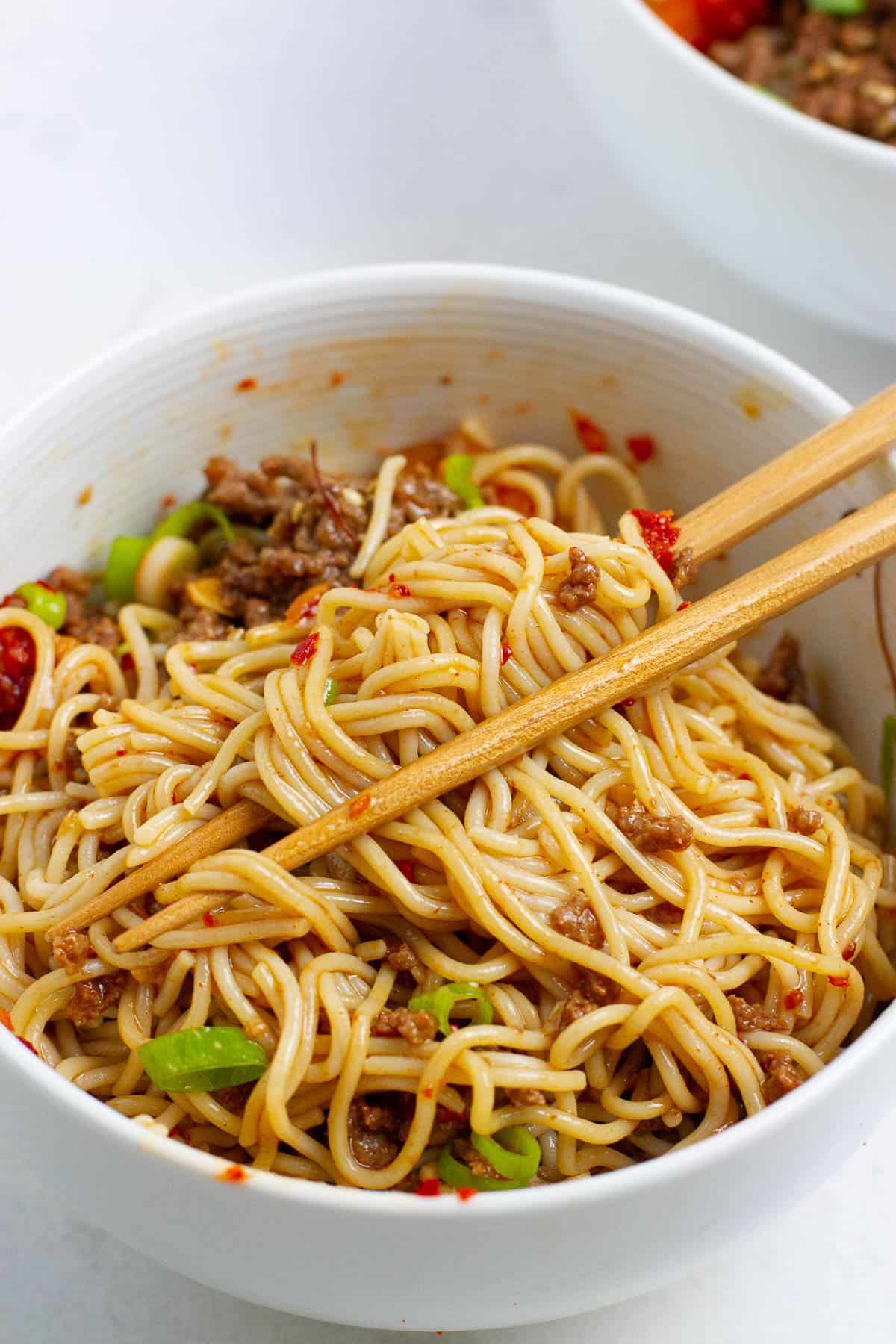Bulgogi noodles being mixed in a bowl.