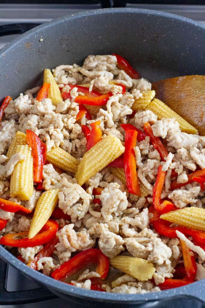 spicy ground chicken stir fry being cooked in a pan.