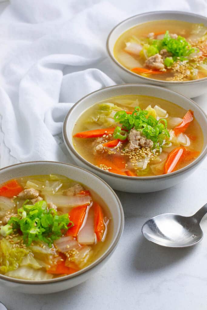 Three bowls of pork napa cabbage soup.
