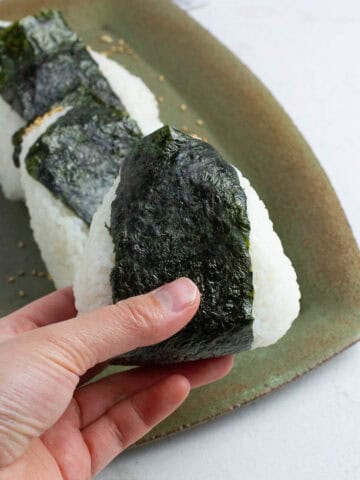 Tuna mayo onigiri held in a hand.