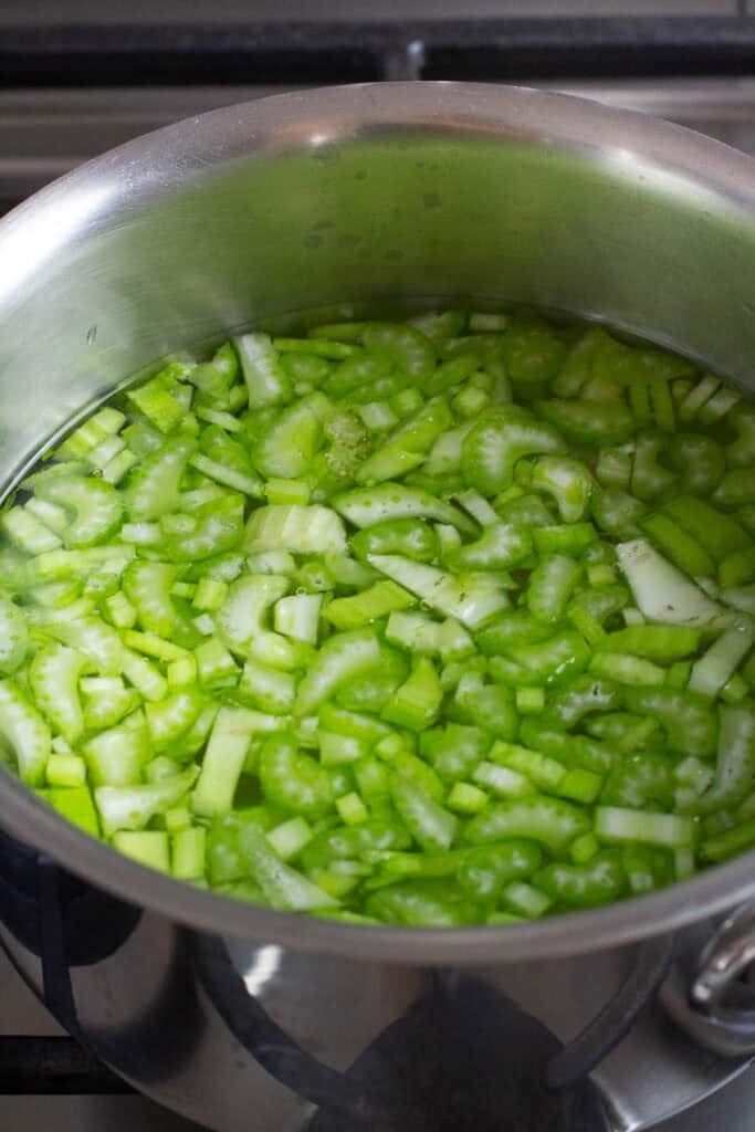 Celery and broth in a saucepan.