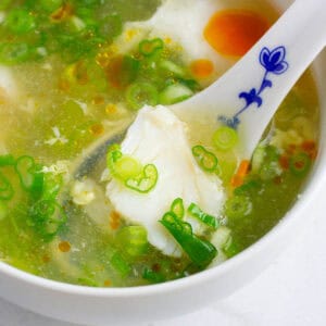 Chunk of cod in a soup spoon.