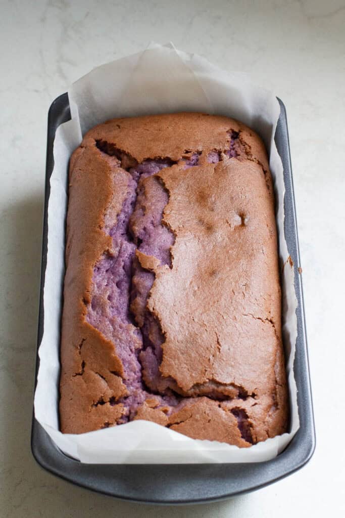 Baked ube loaf cake in a baking pan.