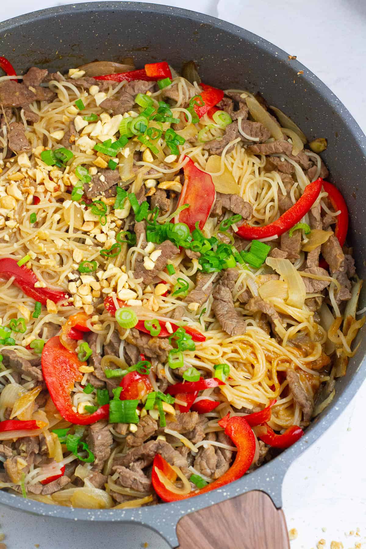 Top view of beef satay noodles in a skillet.