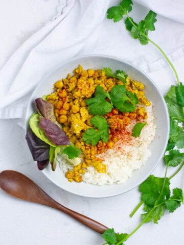 chicken chickpea curried stir fry in a bowl with rice.