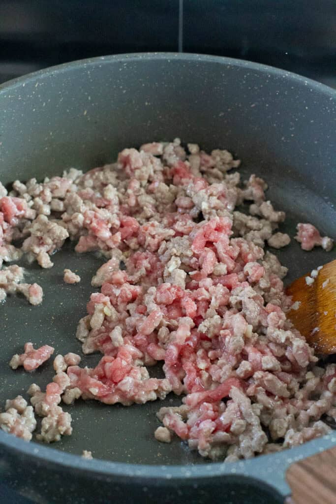 Ground pork being cooked in a pan.
