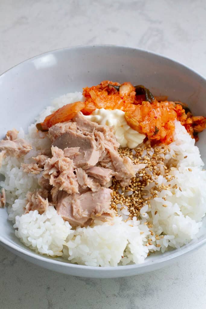 Cooked rice, kimchi and tuna in a bowl.