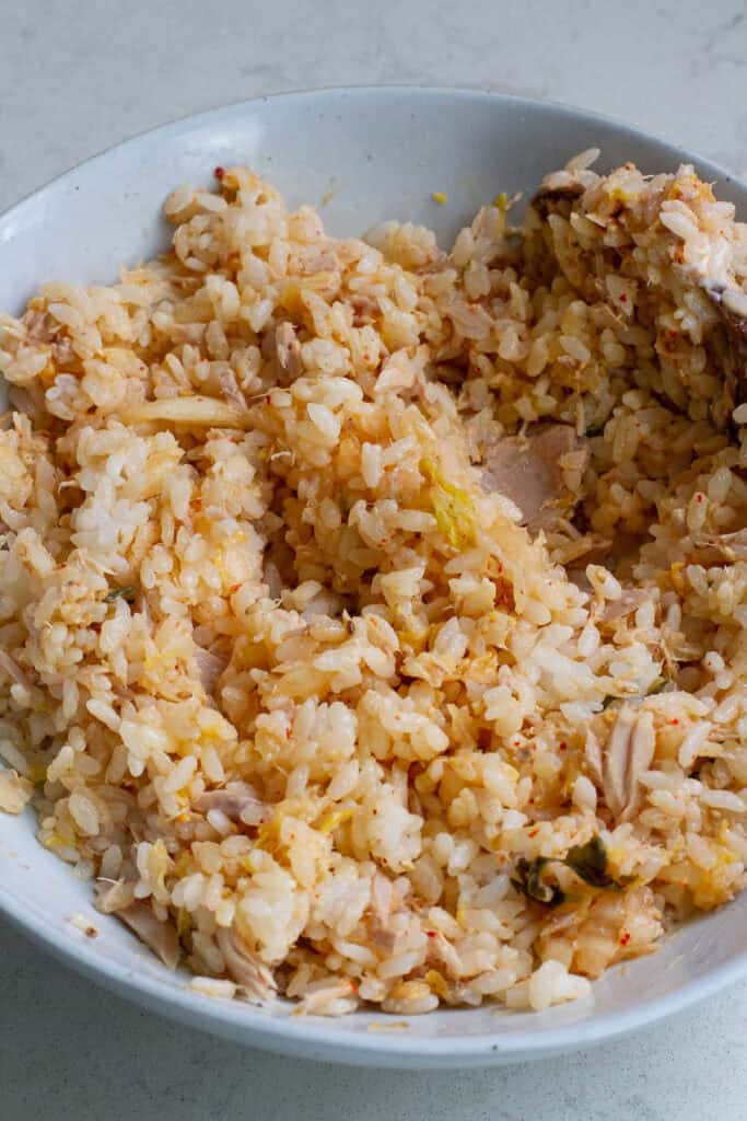Rice, kimchi and tuna mixed in a bowl.