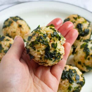 Korean seaweed rice balls held in one hand.