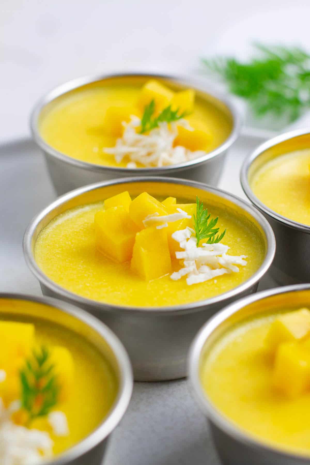 Mango pudding in metal cups.