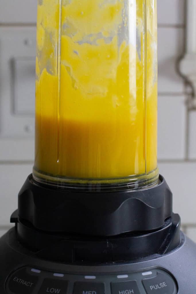 Pureed mango in a blender.