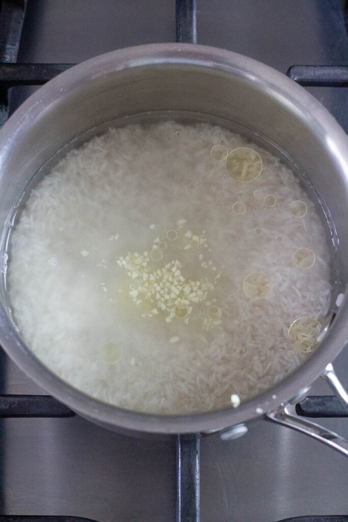 Jasmine rice being cooked in a saucepan.