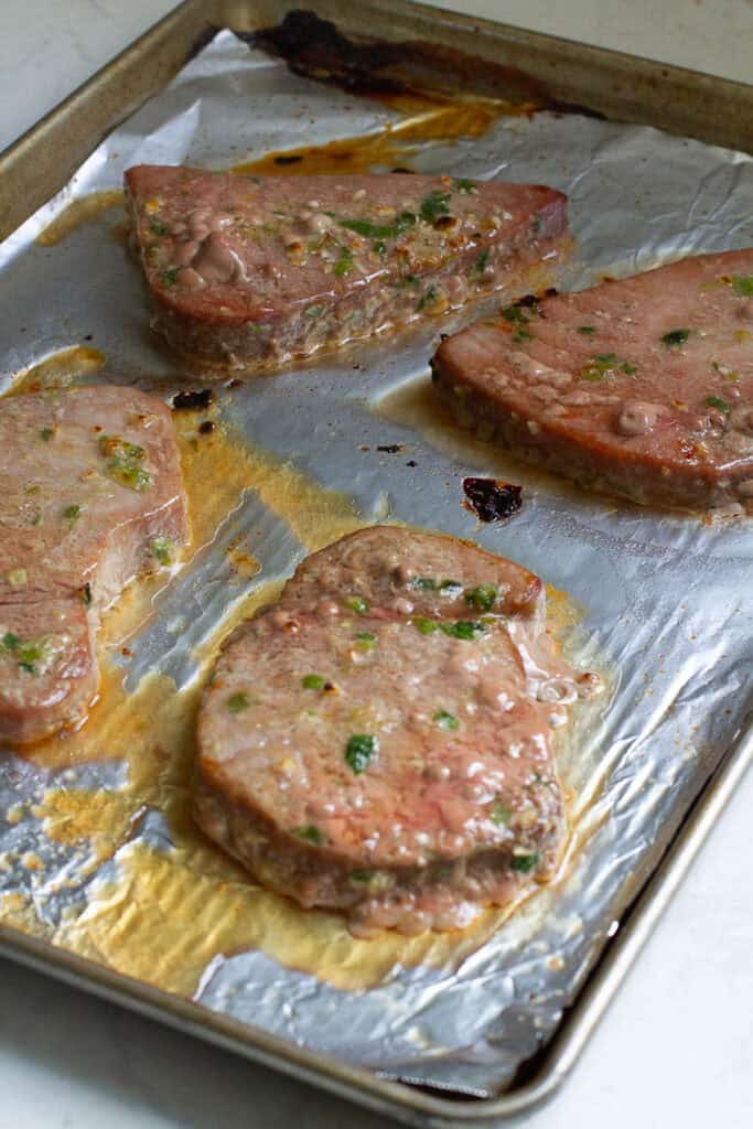 Baked tuna steaks on a baking pan.