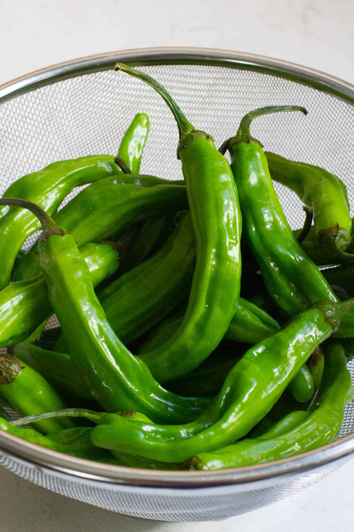 Shishito peppers in a strainer.