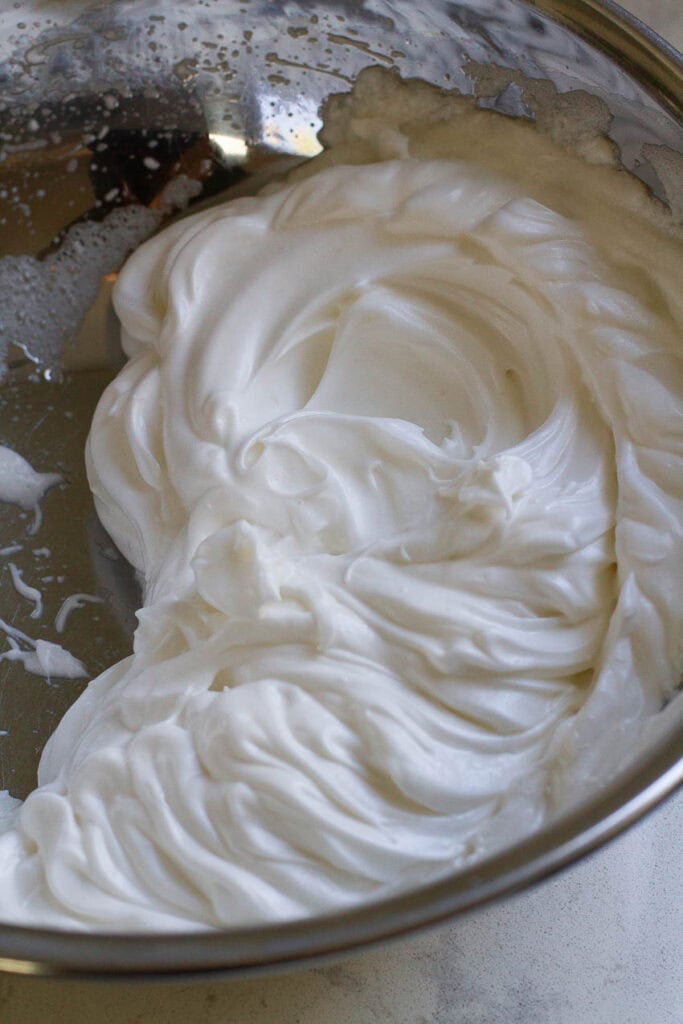 Whipped meringue in a metal bowl.