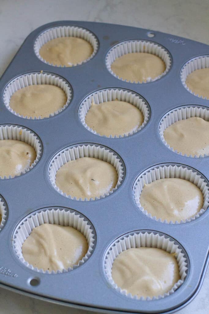 Batter of coffee chiffon cupcakes in a baking tin.
