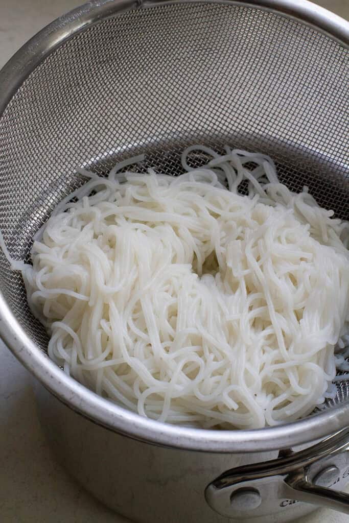 Cooked Vietnamese vermiceli noodles in a strainer.