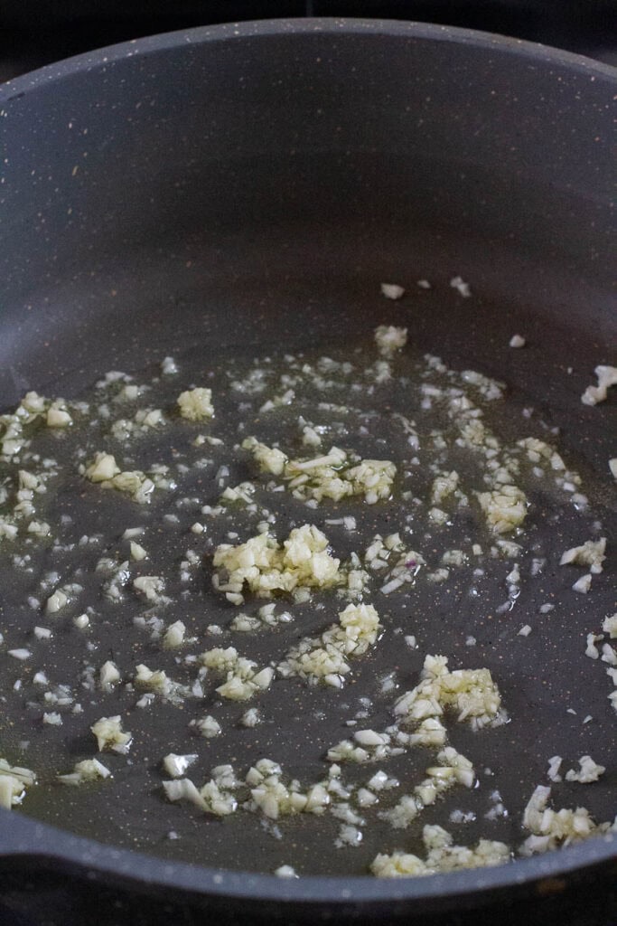Garlic being cooked in a pan.