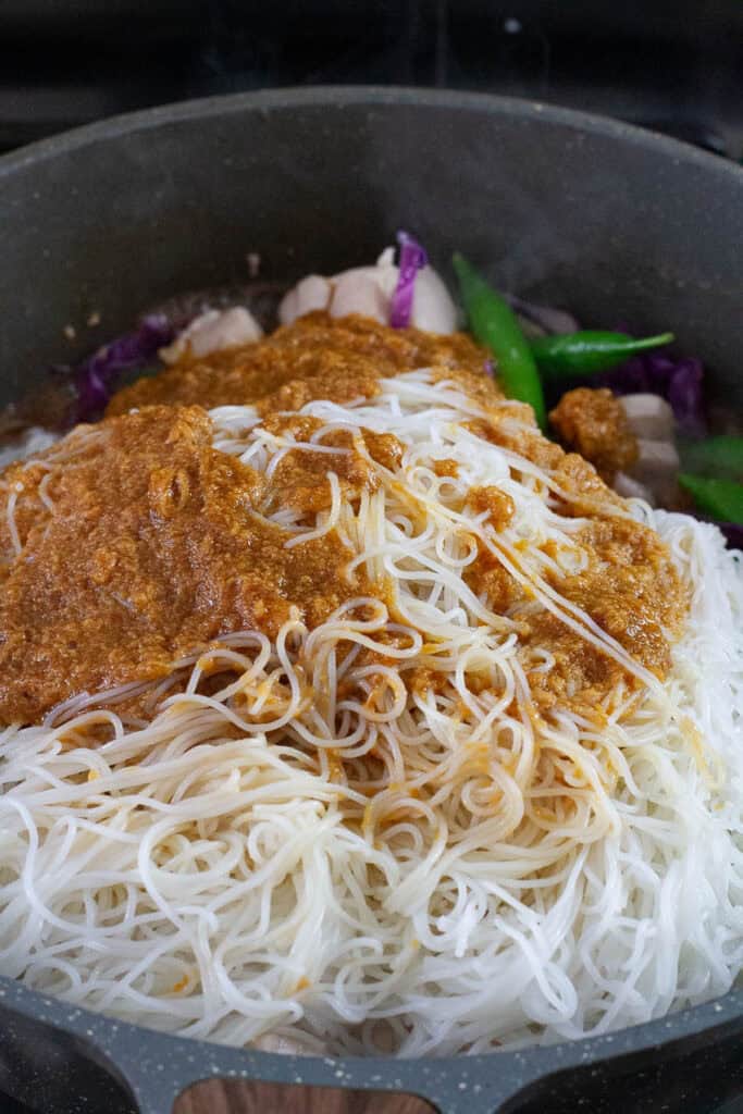 Chicken satay noodles cooked in a pan.