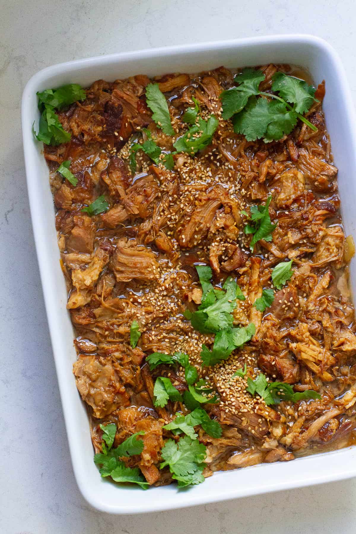 Top view of Instant Pot Asian pulled pork in a square casserole.